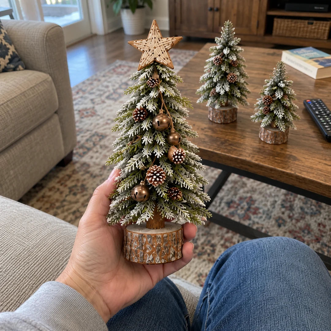 Hand holding the tallest mini snowy Christmas tree showing its compact scale