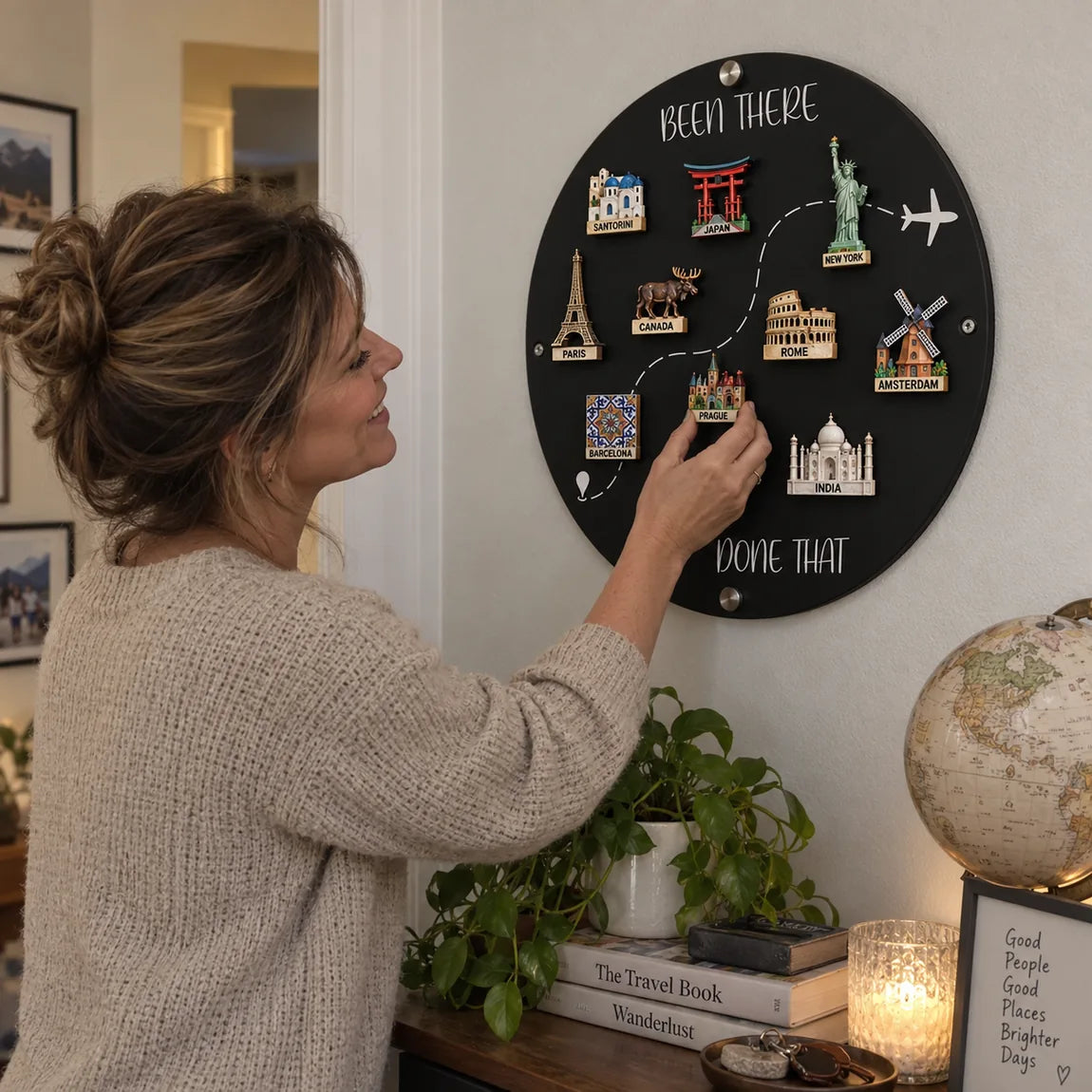 Woman adding a magnet to travel memory board at home