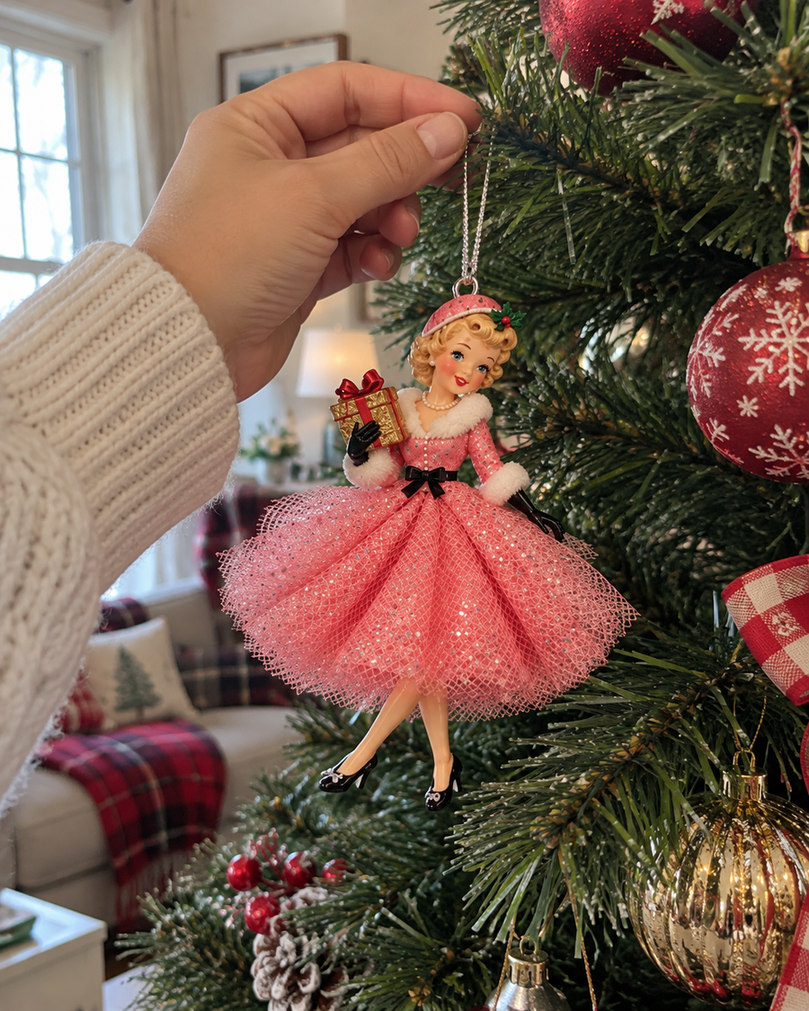 Pink vintage holiday girl hanging ornament shown close to a hand