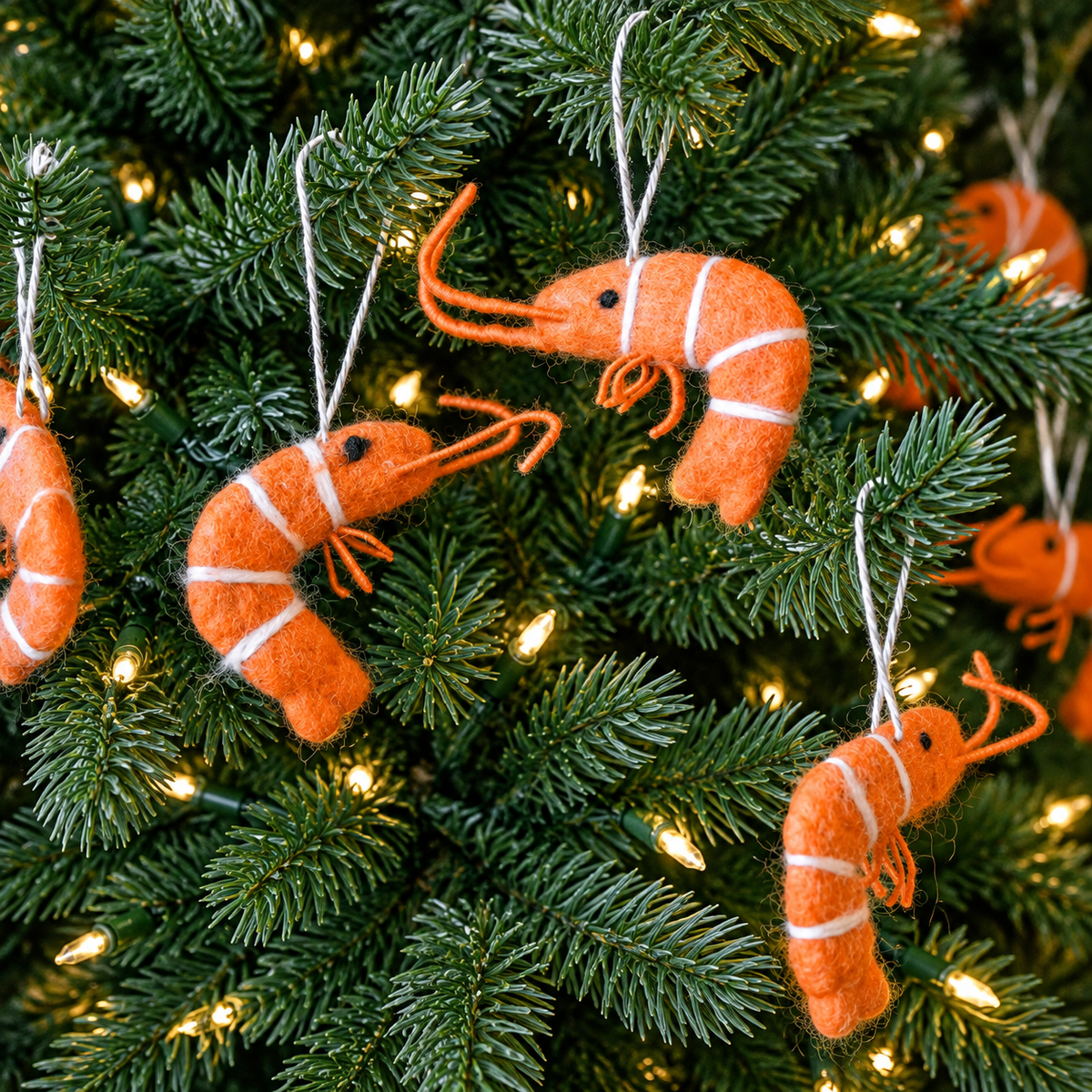 Close-up of felt prawn ornament construction with white stripes and hanging twine