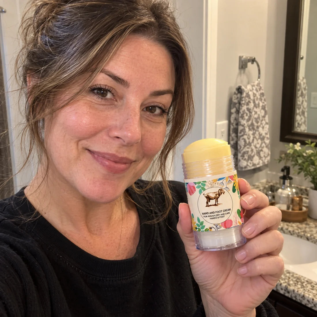 Lifestyle selfie holding the balm stick near a bathroom mirror